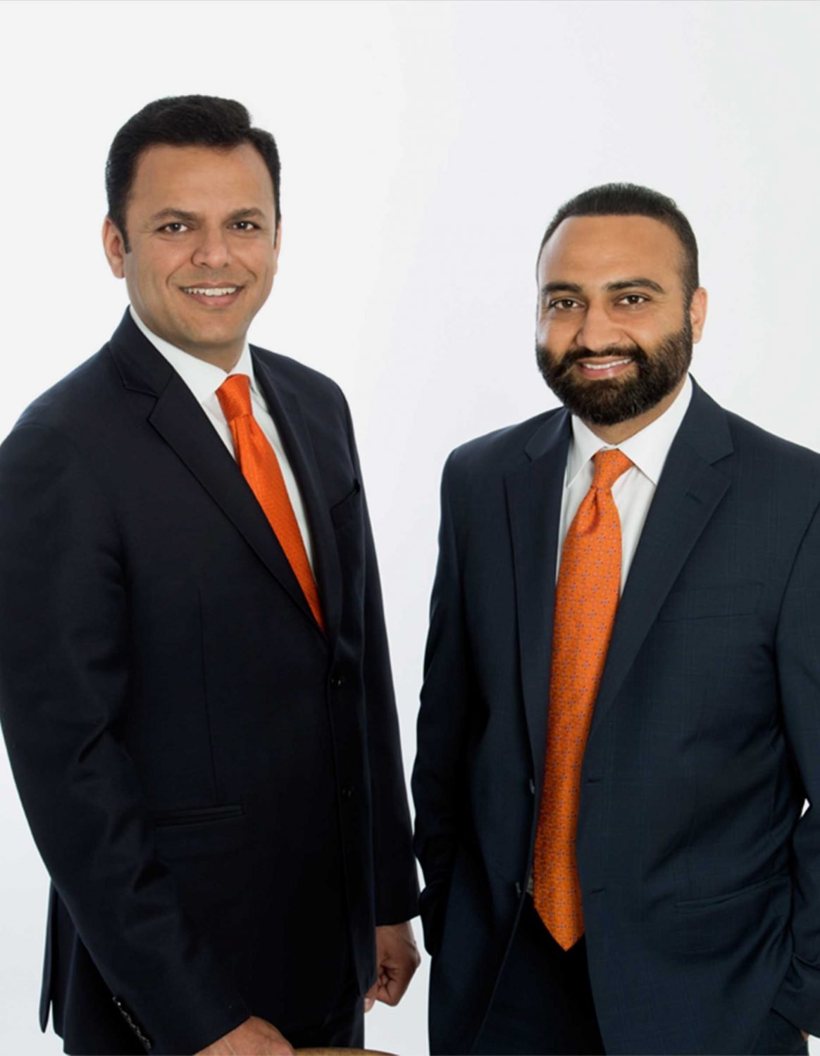 Two men in suits and orange ties