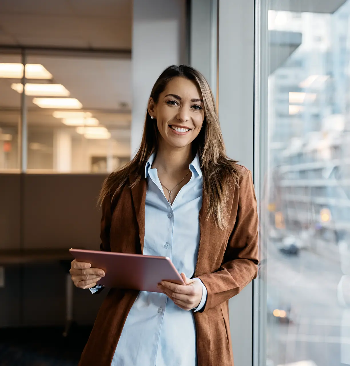 Smiling woman in office with tablet